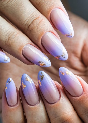 Elegant ombre nail art with gold leaf accents in a sophisticated almond shape.