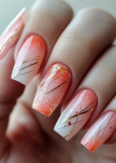 Elegant ombre nail art featuring pastel pink and coral gradient with gold lines and glitter.