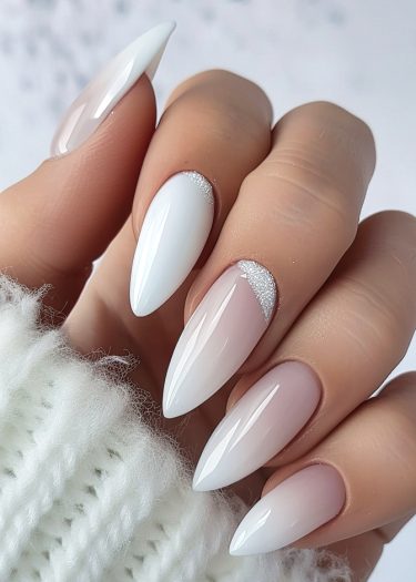 Sophisticated ombre nail design with rhinestones on almond-shaped nails against a cozy background.