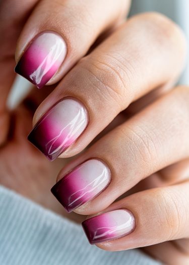 Elegant ombré nails with burgundy gradient and artistic white accents for a stylish manicure.