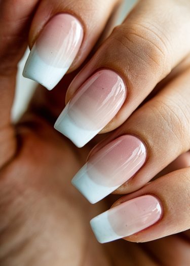 Elegant ombre nails with a pink to white gradient for a sophisticated manicure look.