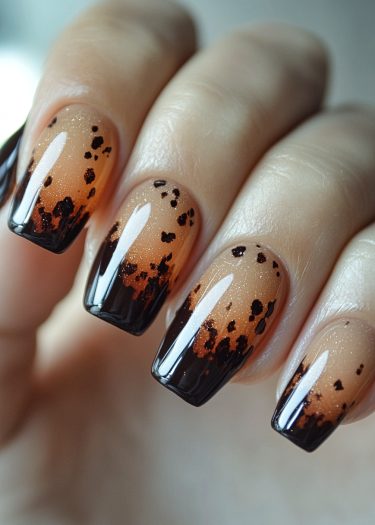 Elegant ombre nails with black speckles in a coffin shape for sophisticated nail art design.