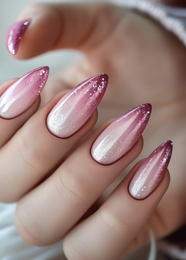 Elegant ombre nails with glitter in pinkish-purple gradient for a chic, sophisticated look.