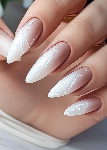 Elegant ombre nails in stiletto shape showcase a sophisticated, glossy manicure.