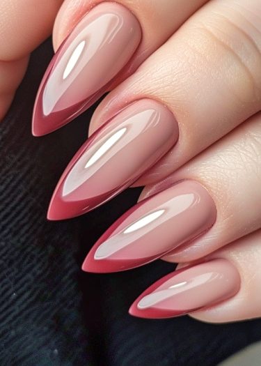 Elegant almond-shaped ombre nails featuring a nude-to-deep red gradient for a chic look.