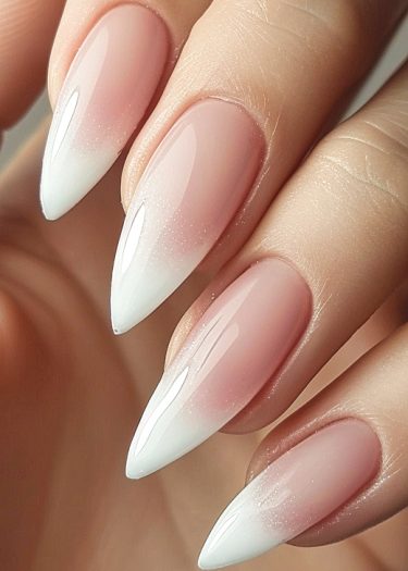 Elegant stiletto nails featuring a pink-to-white ombre design, showcasing luxury and sophistication.