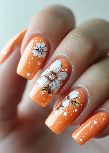 Elegant orange glitter nails with intricate floral designs and playful white dot accents.