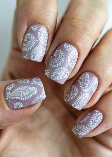 Beautiful lilac nail art featuring intricate white paisley designs for elegant and sophisticated style.