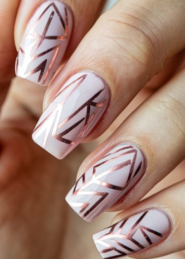 Elegant pale pink nail art with metallic rose gold geometric designs for a chic look.