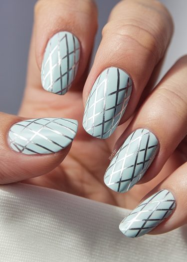 Elegant pastel blue nails with silver grid design for a sophisticated manicure style.