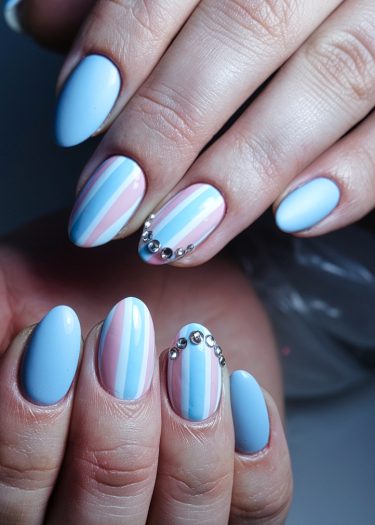 Elegant pastel nail art featuring rhinestones on almond-shaped nails in soft colors.