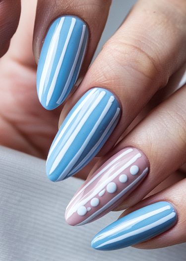 Elegant pastel nail art featuring striped and dotted designs in soft blue and pink hues.