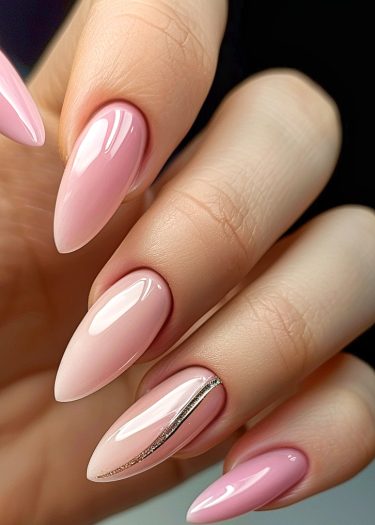 Elegant pastel pink almond-shaped nails with a metallic accent for a sophisticated look.