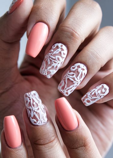 Elegant peach coffin nails with intricate white 3D designs and glossy finish for a stylish look.