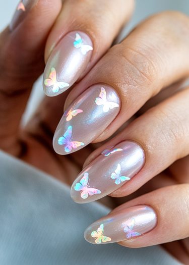 Elegant pearl manicure featuring whimsical pastel butterfly decals on glossy almond-shaped nails.