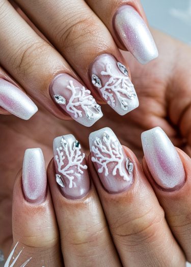 Elegant pearl winter nail art with intricate coral patterns and sparkling rhinestones.