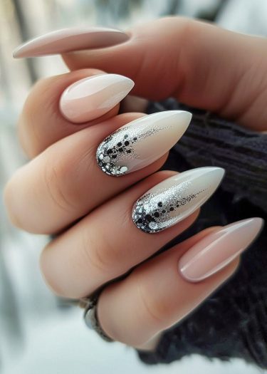 Elegant almond-shaped pink nails with glamorous black dot designs and silver glitter art.