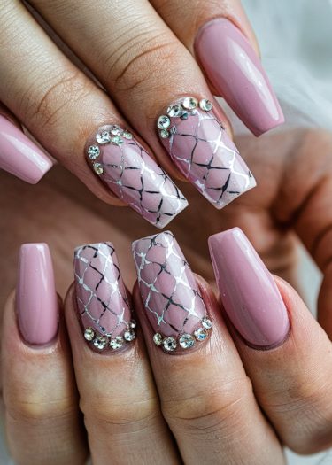 Elegant pink coffin nails with intricate silver patterns and sparkling rhinestones for a glamorous look.