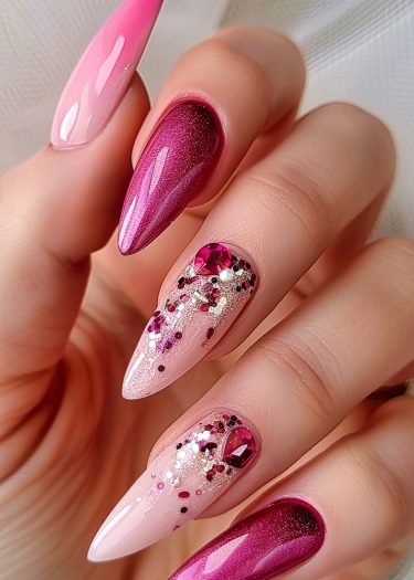 Elegant pink gradient nails with glitter, rhinestones, and metallic accents for a luxurious look.