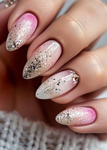 Stunning almond-shaped nails feature a pink-to-gold gradient with glitter and a star embellishment.