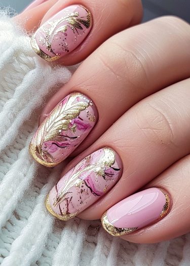 Elegant pink and gold nail art featuring marbling and floral designs for a luxurious look.