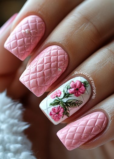 Elegant pink manicure with quilted acrylic nails and floral accent design.