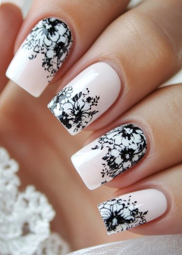 Elegant white floral nail art on manicured square nails with glossy finish and lace background.