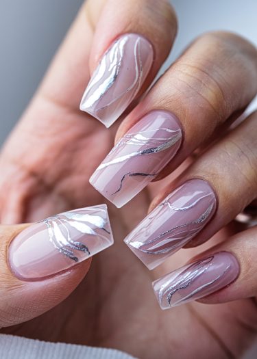 Elegant pink nail art with intricate silver designs on coffin-shaped nails.