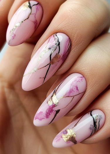 Elegant pink nail art with abstract black and gold designs, perfect for modern sophistication.