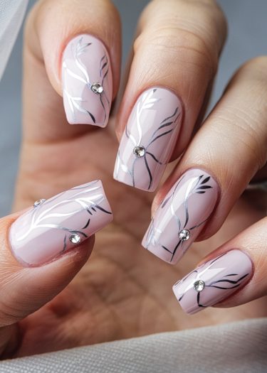 Elegant pink nail art featuring intricate designs and rhinestones for a chic manicure look.