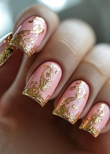 Elegant pink nail art with gold foil designs for a luxurious and sophisticated look.