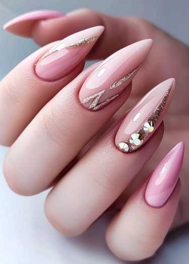 Elegant stiletto pink nails with gold glitter and iridescent accents for a chic manicure.