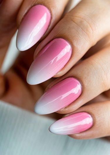 Elegant pink and white gradient almond nails showcasing a glossy manicure.