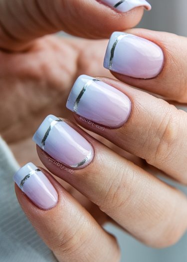 Elegant pink and lavender ombre nails with metallic silver accents for a chic manicure.