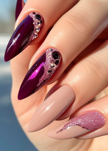 Elegant plum and nude stiletto nail art with glitter and rhinestones for a luxurious look.