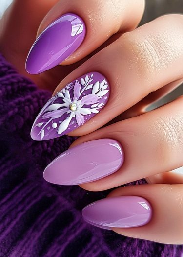 Elegant almond-shaped purple nails with floral design on a luxurious dark background.