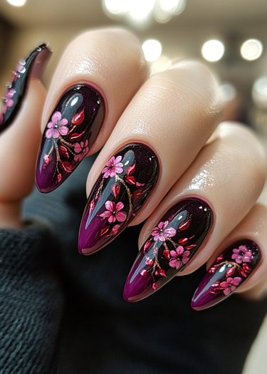 Stunning stiletto nails with glossy black base and vibrant pink floral designs.