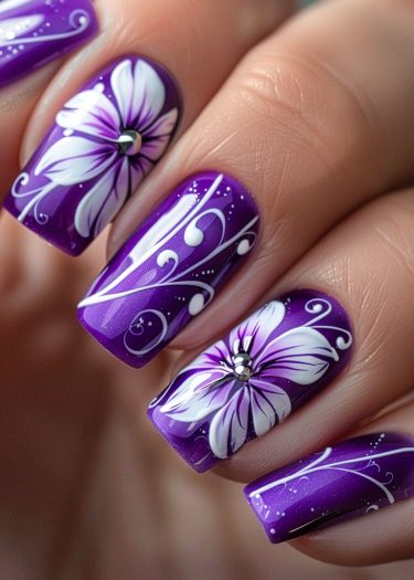 Elegant purple floral nails with rhinestones and artistic swirls for a sophisticated manicure.