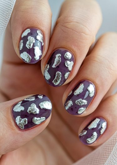 Elegant purple nail art with silver foil accents, showcasing a creative, modern design.