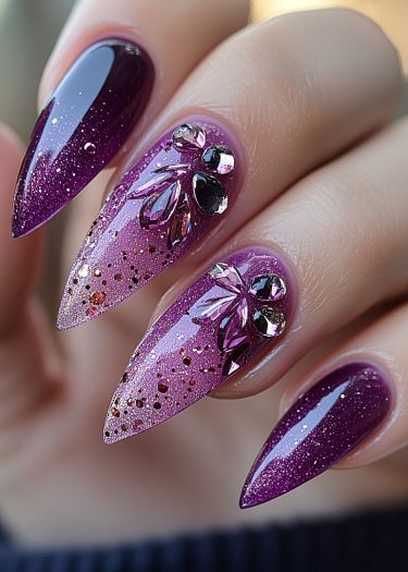 Elegant purple stiletto nail art with rhinestones and glitter for a glamorous look.