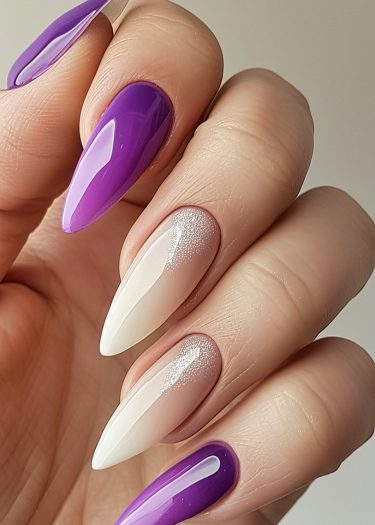 Elegant purple nail art with almond shapes and shimmering accents for a sophisticated look.