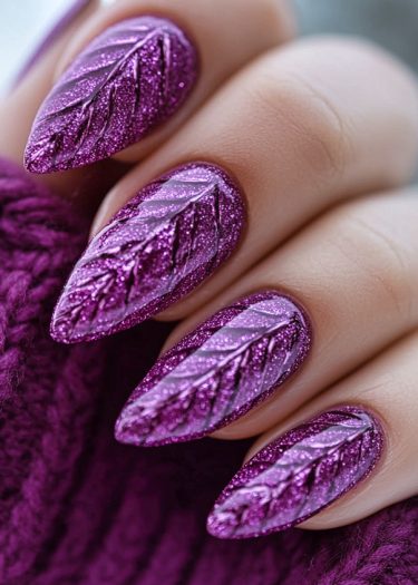 Elegant purple stiletto nails with intricate leaf designs and glittery accents on a cozy background.