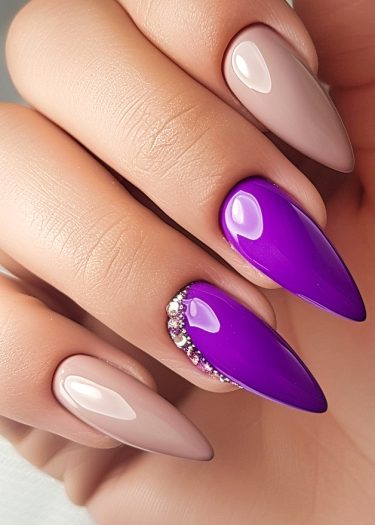 Elegant purple and nude manicure with rhinestones, showcasing sophisticated nail art design.