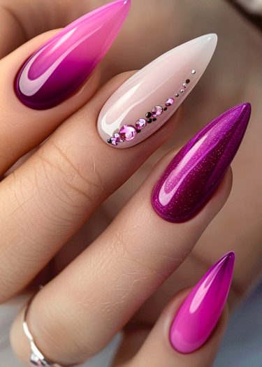 Elegant pink and magenta stiletto nails with rhinestones for a glamorous manicure look.