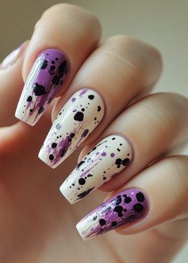 Elegant purple and black splatter nail design on a creamy white background.