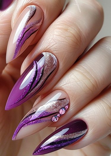 Elegant purple stiletto nails with glitter and rhinestones for a stunning nail art design.