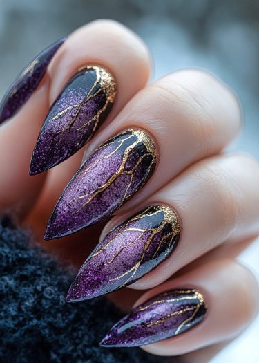 Elegant purple stiletto nails with gold accents showcasing stunning ombre nail art design.