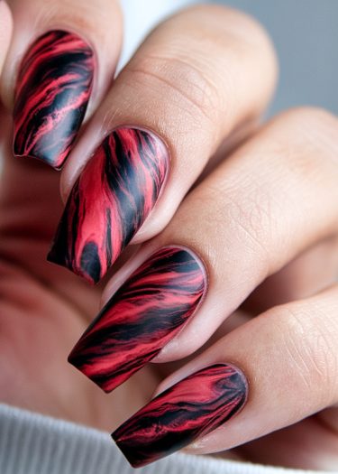 Stunning coffin-shaped red and black marbled nail art showcasing elegant nail design techniques.