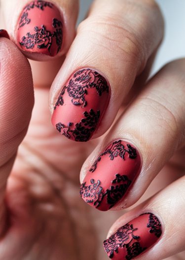 Elegant red matte nail art with intricate black floral design for stunning manicure inspiration.