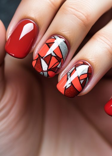 Artistic red nail art featuring geometric designs and a glossy finish for elegant style.